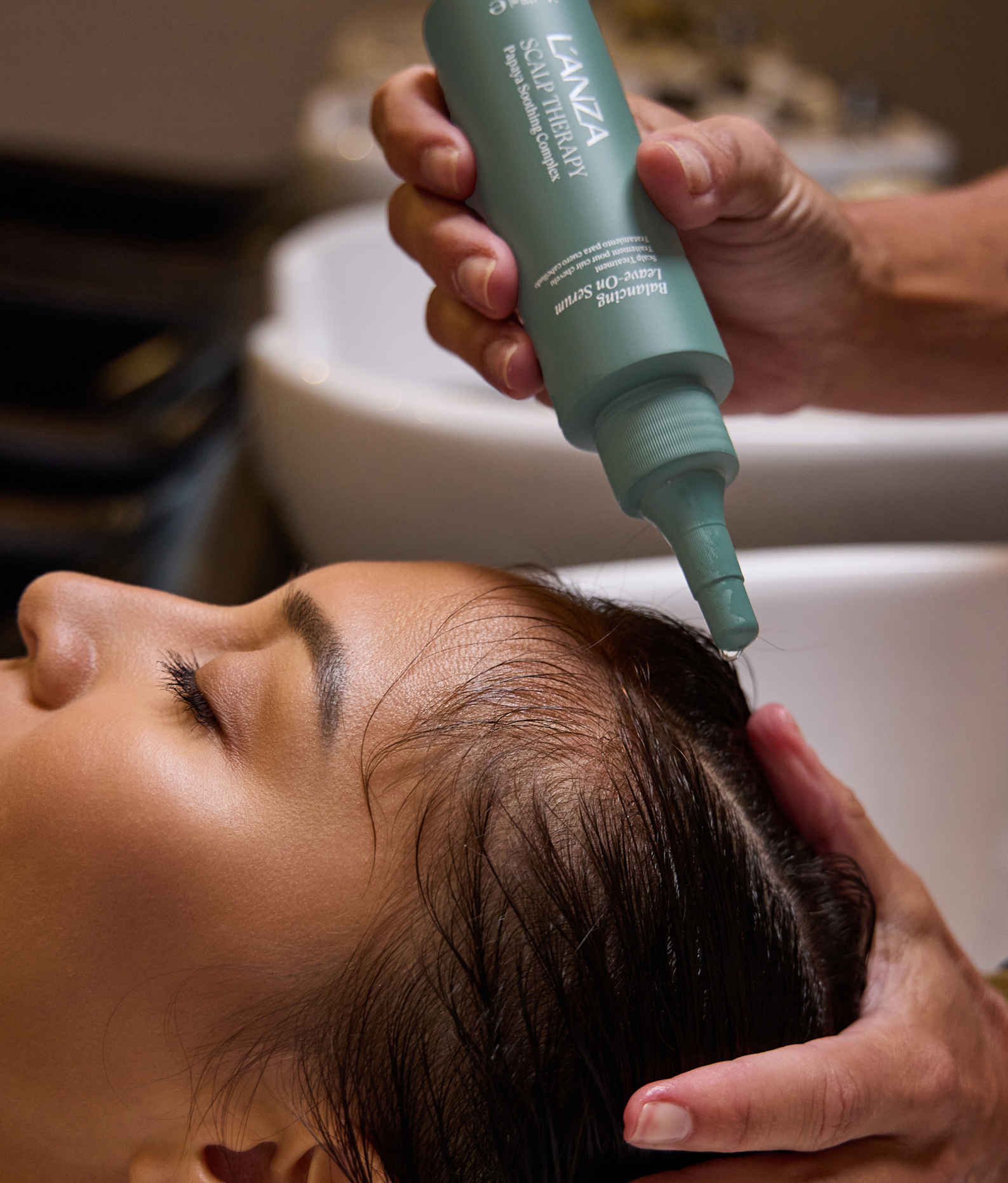 Een kapper brengt Scalp Therapy Leave-On Serum aan op de hoofdhuid